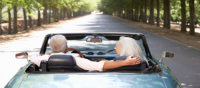 Elderly couple driving convertible